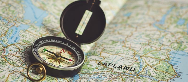 En kompass ligger på en utbredd vandringskarta