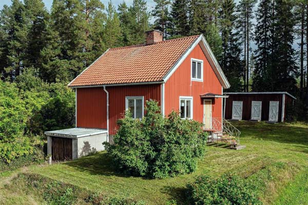 Gesamtansicht von Bettys Hus im Sommer, umgeben von Bäumen