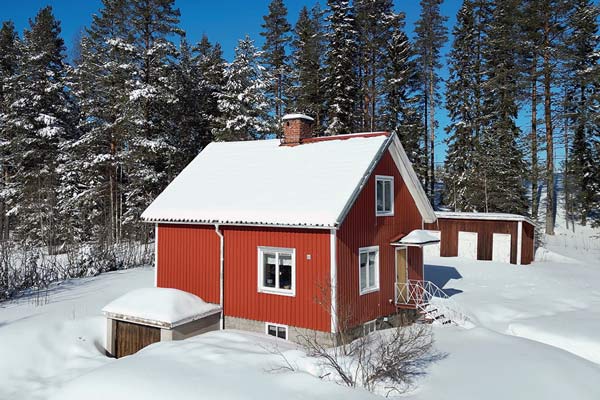 Außenansicht des Hauses im tiefen, unberührten Winterschnee