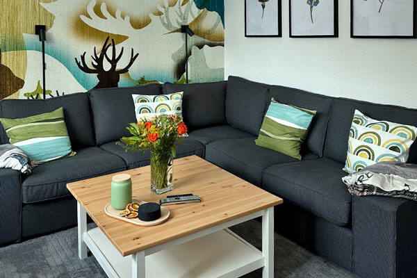 Das gemütliche Wohnzimmer mit Sofa und Blick zum Kamin