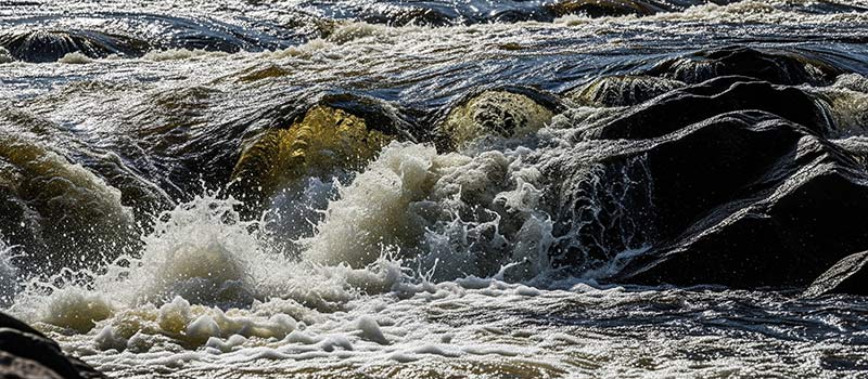 Vatten stänker över klipporna i Vindelforsarna.